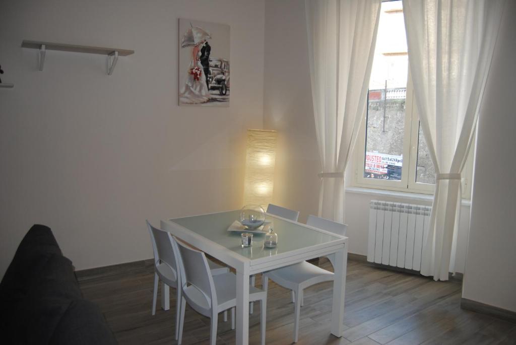 - une table et des chaises blanches dans une chambre avec fenêtre dans l'établissement Le Bon Bon, à Naples