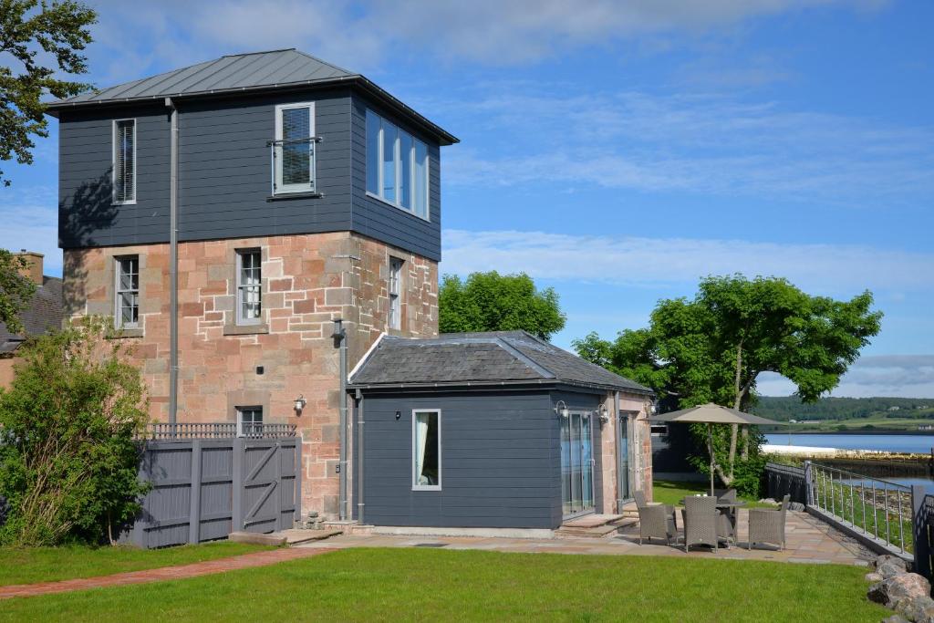 ein schwarzes Haus mit einer Garage darüber in der Unterkunft Tangle Tower in Inverness