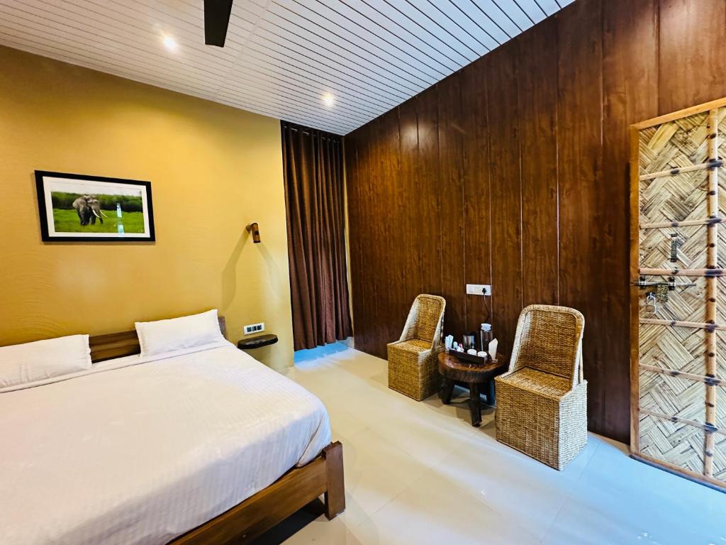 a bedroom with a bed and a table and chairs at Kaziranga Tea Nest Homestay in Kāziranga