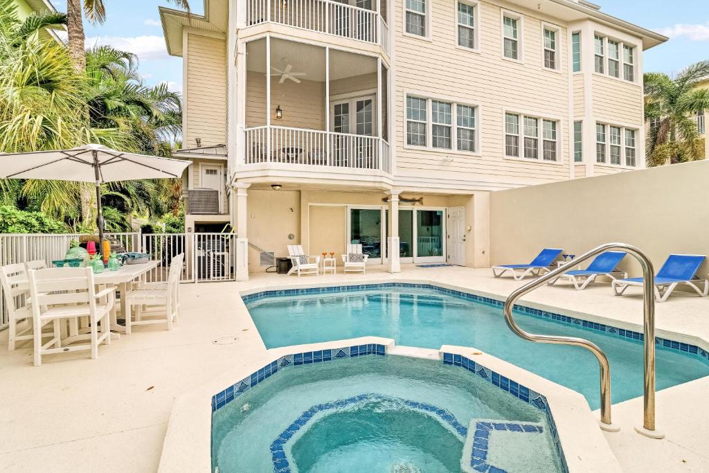 Una piscina frente a una casa con una mesa y sillas. en The Key Canal - 455, en Siesta Key