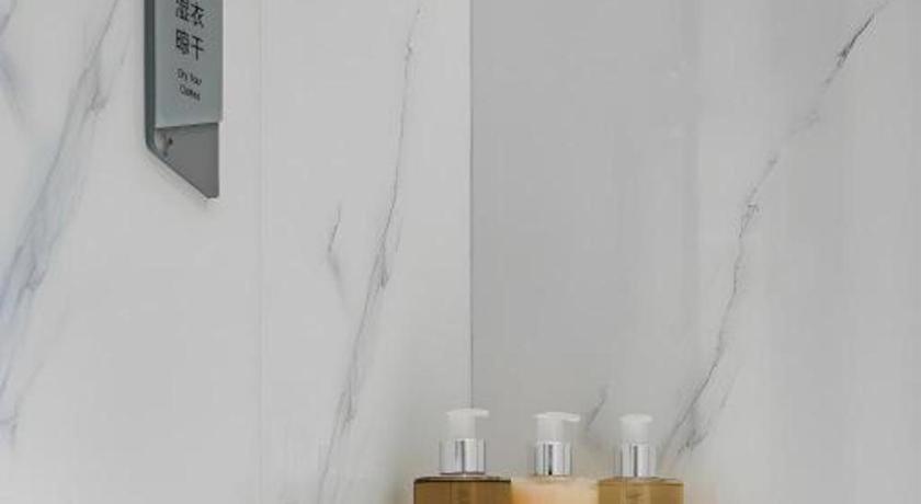 eine Gruppe weißer Kerzen neben einer Wand in der Unterkunft Borrman Hotel Xi'an North High-speed Railway Station in Xi'an