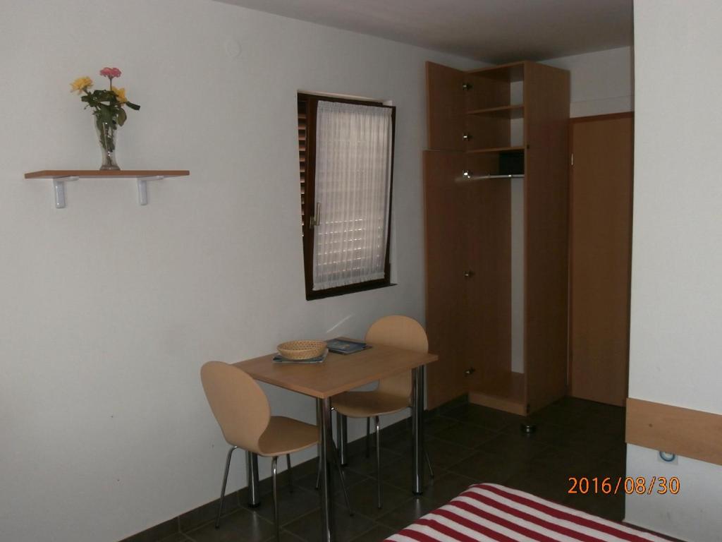 a small table and chairs in a room at Apartments Meni in Drage