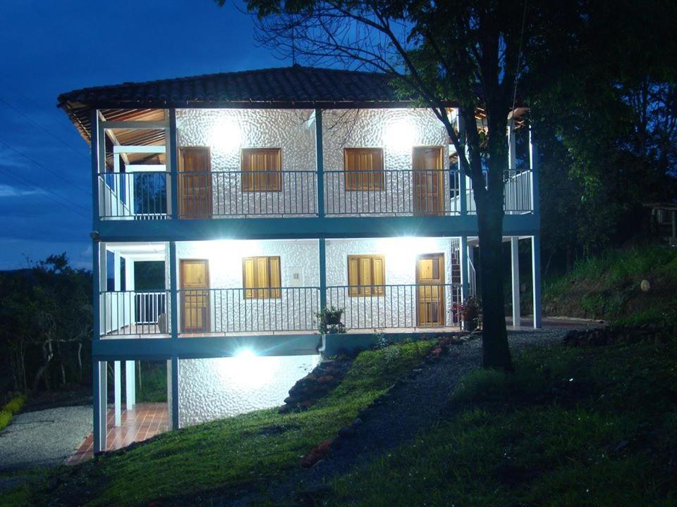 a large white building with lights on it at night at Hotel Ecoturistico Villa Lucy in Curití