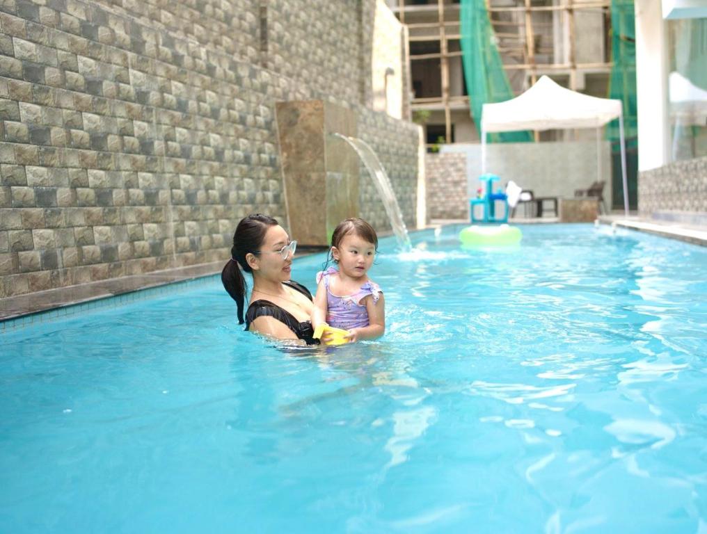 uma mulher e uma criança em uma piscina em Khamsum Phuntsholing em Phuntsholing