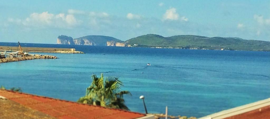 Blick auf einen großen Wasserkörper mit Bergen in der Unterkunft Appartamento Francesca in Alghero