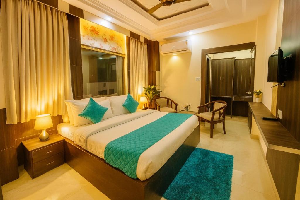 Un dormitorio con una cama grande y un televisor. en Hotel Ramawati, A Luxury Hotel & Resort, Haridwar, en Haridwar