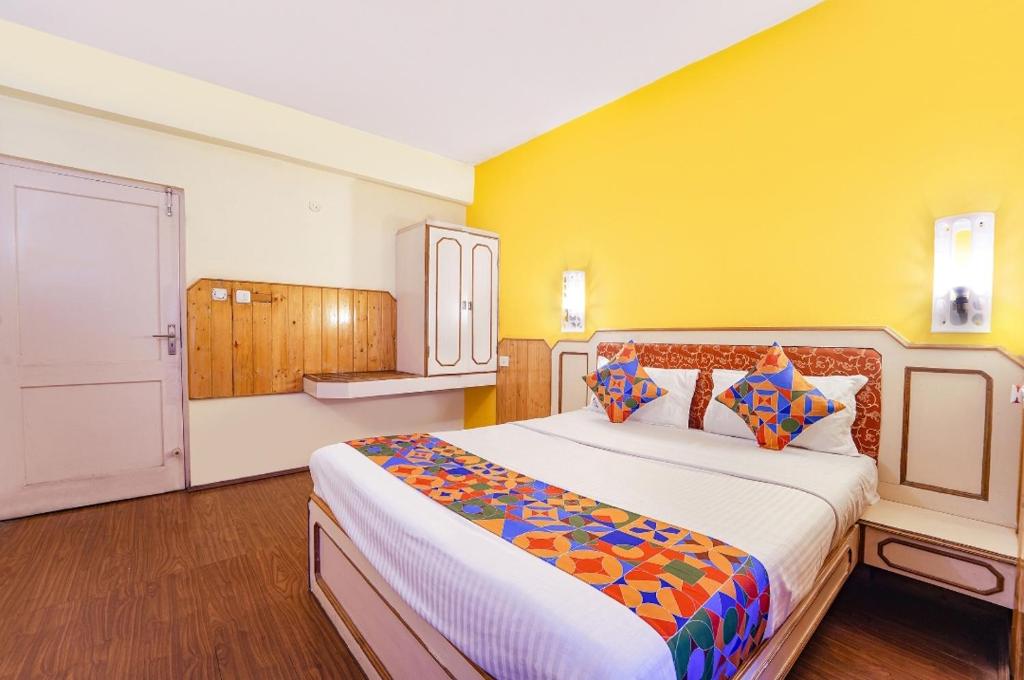 科代卡纳尔JS Heritage的一间卧室设有一张大床和黄色的墙壁