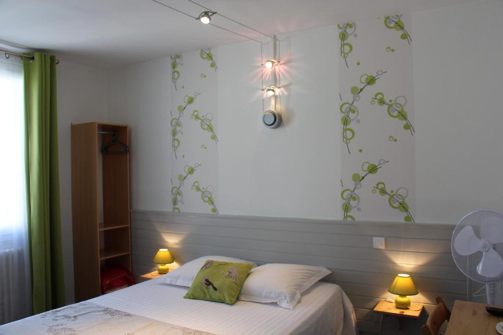 a bedroom with a bed with green leaves on the wall at Hotel d'Orléans in Angoulême