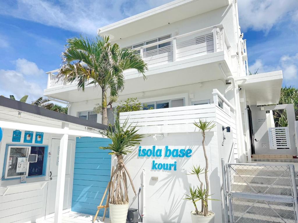 a white house with a sign that reads koala baseount at 全室オーシャンビュー外階段付き一棟貸切プライベートヴィラ in Kouri