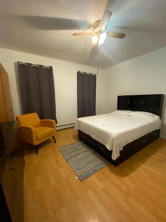 a bedroom with a bed and a ceiling fan and a chair at Simple room in Paterson