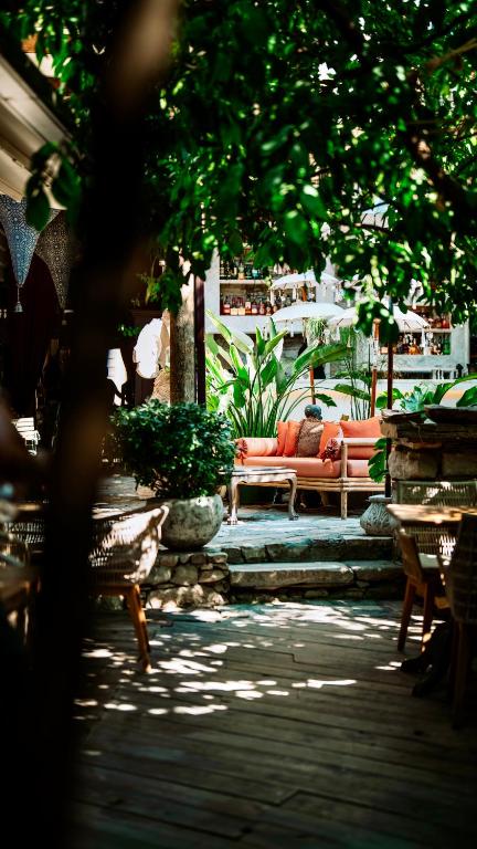 a patio with a couch and chairs under a tree at istifci in İzmir