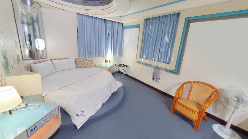 a bedroom with a bed and a desk and a chair at Hua Ku Hotel in Tainan