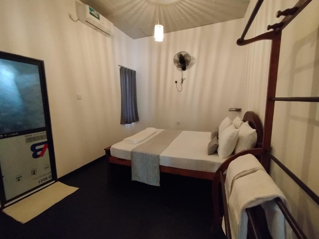 Una pequeña habitación con una cama y un televisor. en Step Inn Ahangama, en Ahangama
