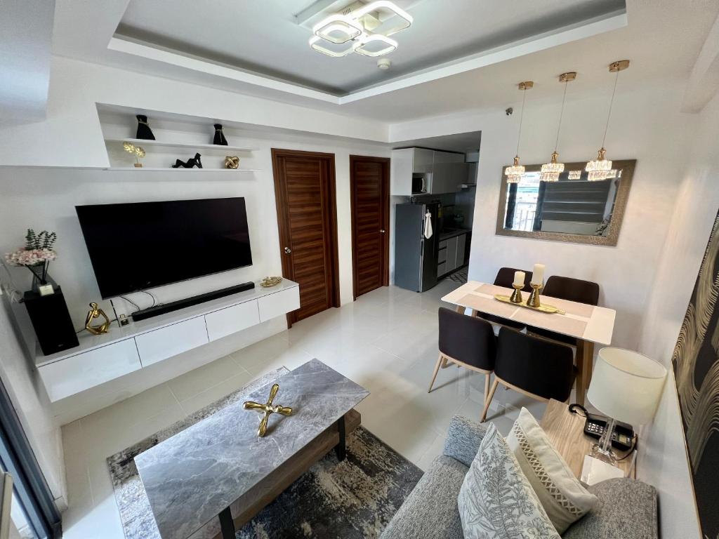 a living room with a large television and a table at Cozy 2BR with Parking Space - Horizon 101 in Cebu City