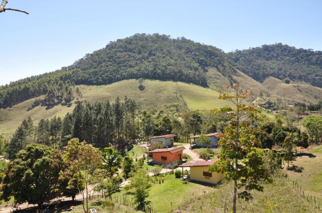 a house on a hill in front of a mountain at Eco Pousada Eldorado Lumiar in Lumiar