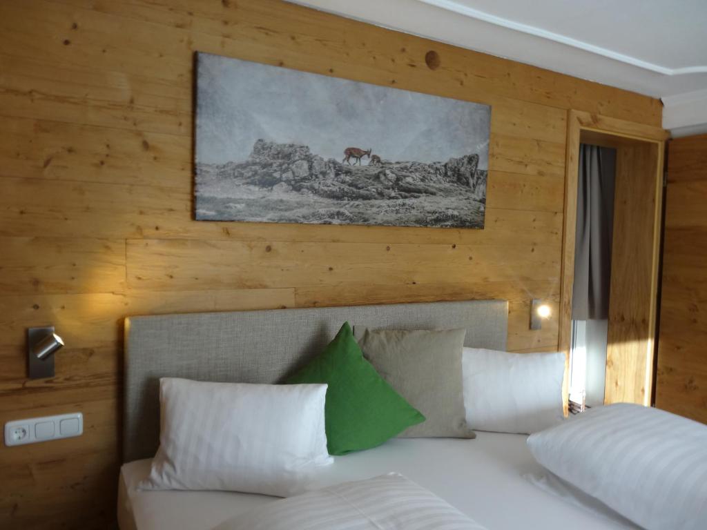 ノイキルヒェン・アム・グロースヴェンエーディガーにあるBhome Gästehaus b&b / Apartmentsのベッドルーム1室(壁に絵画が描かれたベッド1台付)