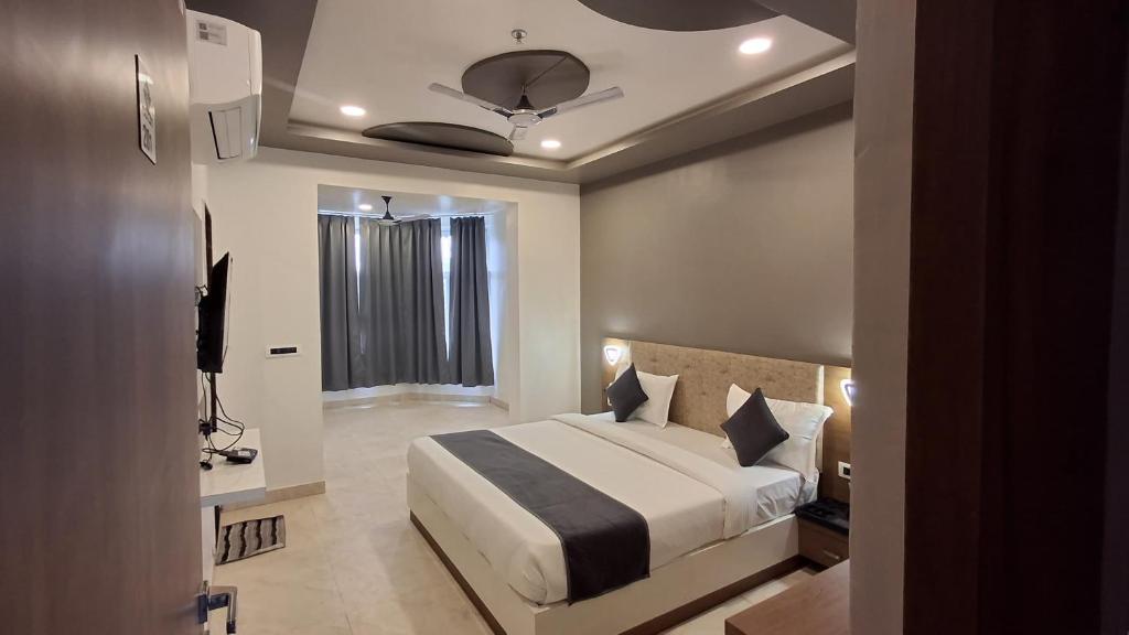 Un dormitorio con una cama grande y una ventana. en Omnitel Kohinoor, en Udaipur