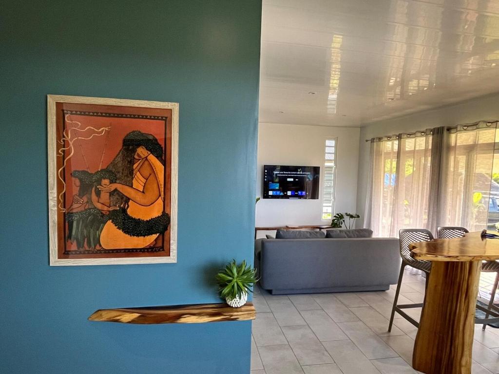 a living room with a painting on a blue wall at Fare Araea in HUH