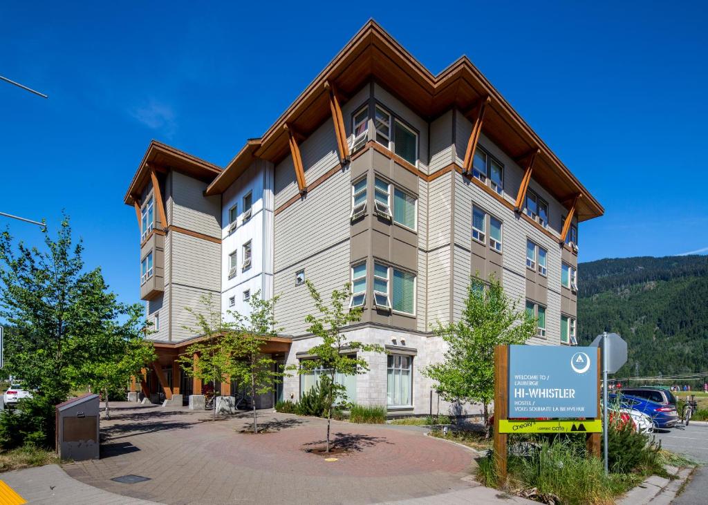 een groot appartementencomplex met een bord ervoor bij HI Whistler - Hostel in Whistler