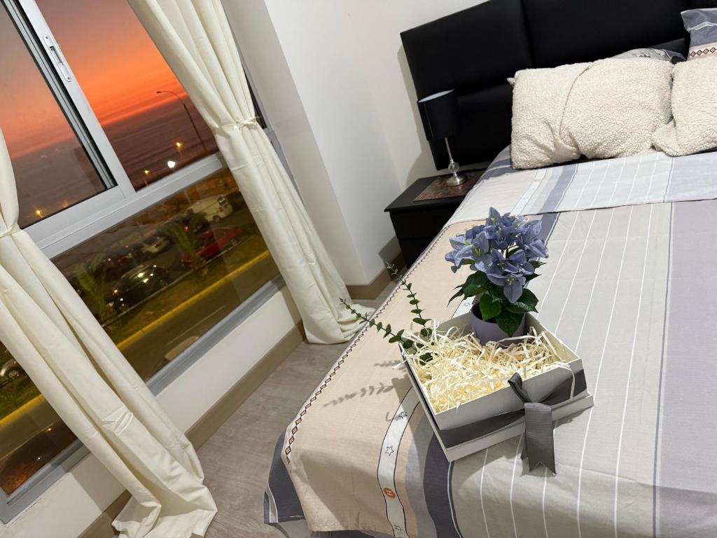 um quarto com uma cama com uma flor numa caixa em Departamento frente al mar costa verde em Lima