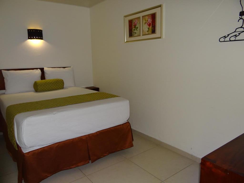 ein Schlafzimmer mit einem großen Bett in einem Zimmer in der Unterkunft Veranda Hotel in San Pedro Sula