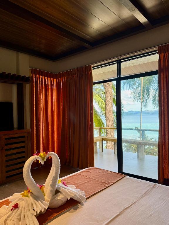 a bedroom with two swans in towels on a bed at Chindonan Dive and Beach Resort in Coron
