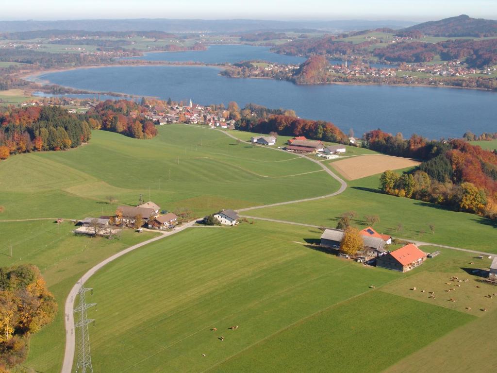 eine Luftansicht auf ein großes, grünes Feld mit einem See in der Unterkunft Baby- und Kinderhof Aicherbauer in Seeham