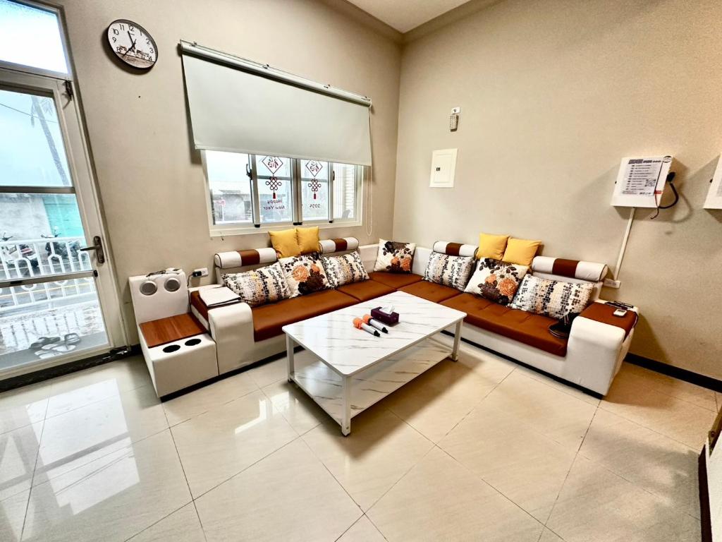 ein Wohnzimmer mit Sofa und Tisch in der Unterkunft 小琉球旭日之外海景包棟 in Xiaoliuqiu