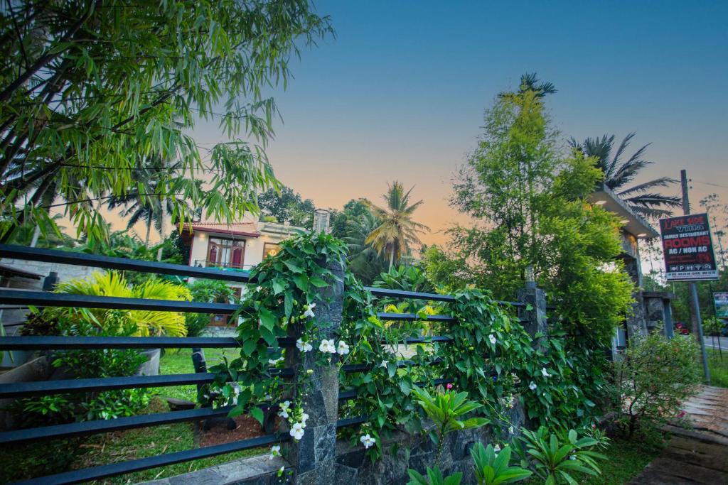 Lakeside Villa : سياج عليه زهور بيضاء بجوار الأشجار