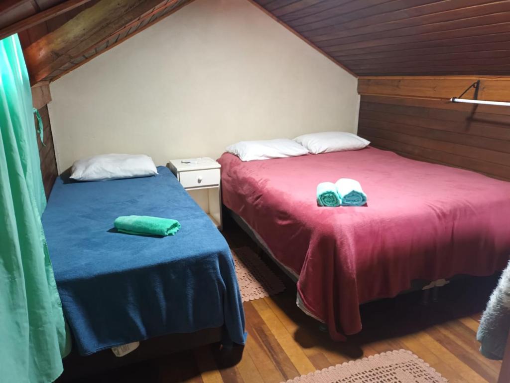 two beds in a room with red and blue sheets at Casa Villagio - CONDOMÍNIO in Gramado