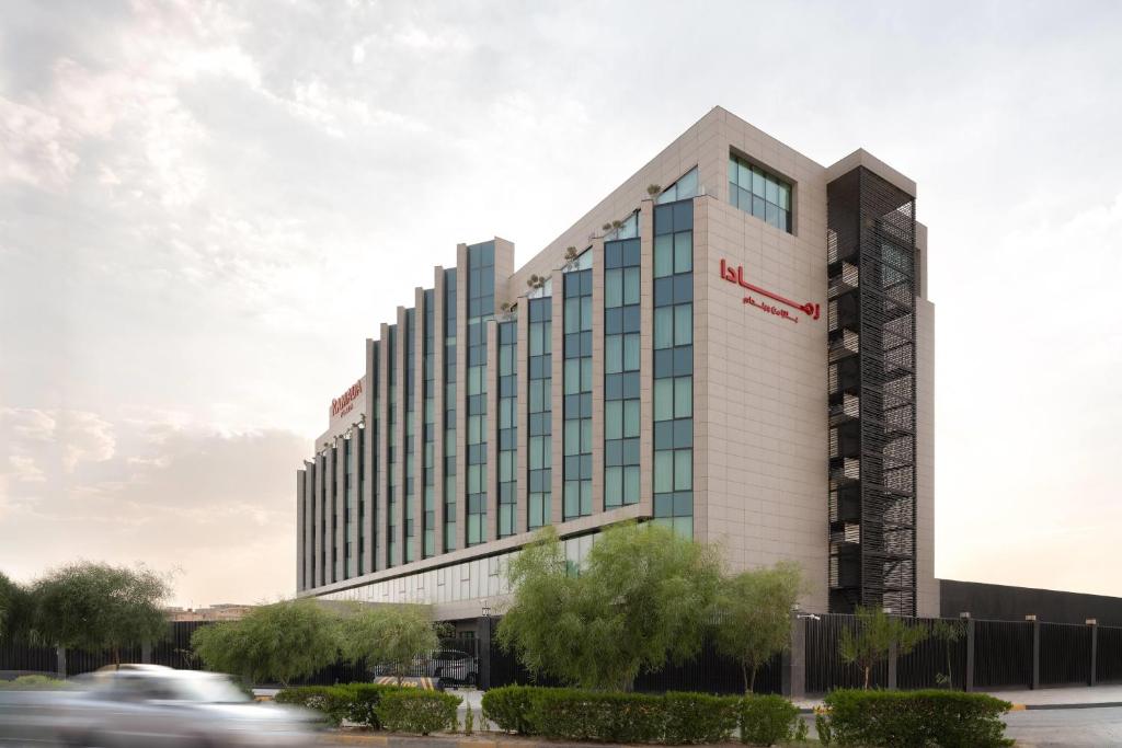 een hotelgebouw waar een auto langs rijdt bij Ramada Plaza by Wyndham Mosul Corniche in Al Mawşil