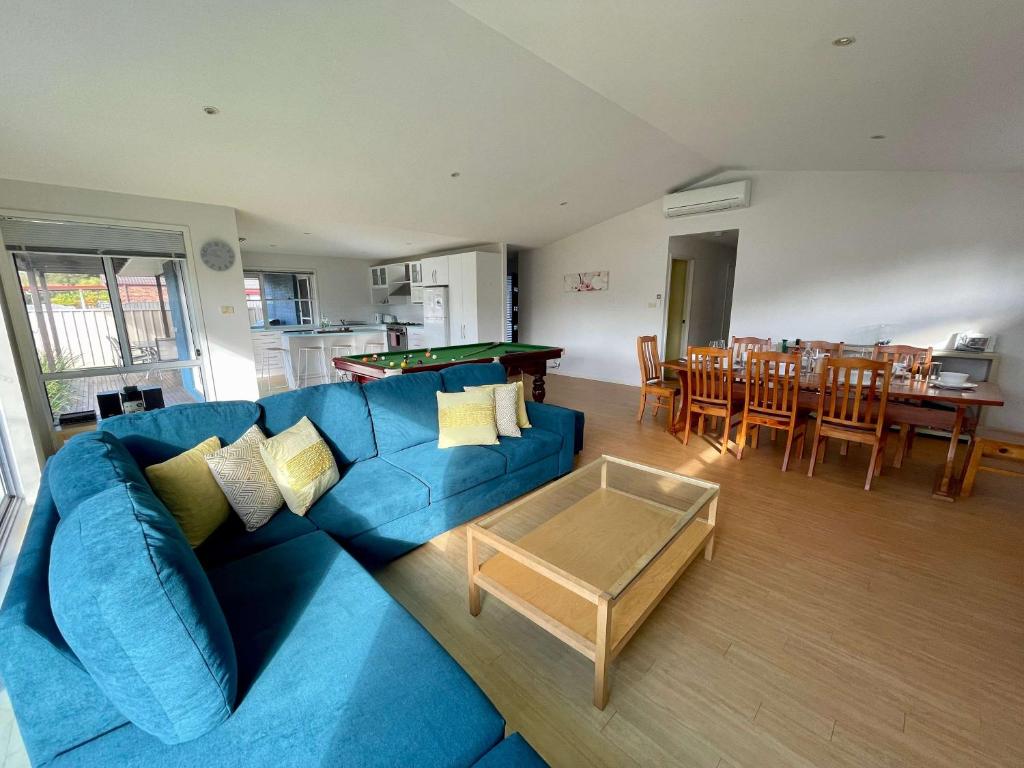 un salon avec un canapé bleu et une table dans l'établissement The Coastal Haven, à Manyana