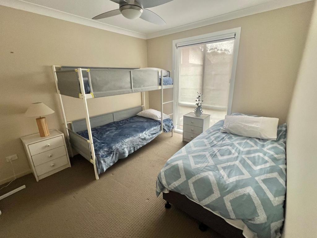 a bedroom with a bunk bed and a window at The Burra Spa, Games & Beach House in Culburra Beach