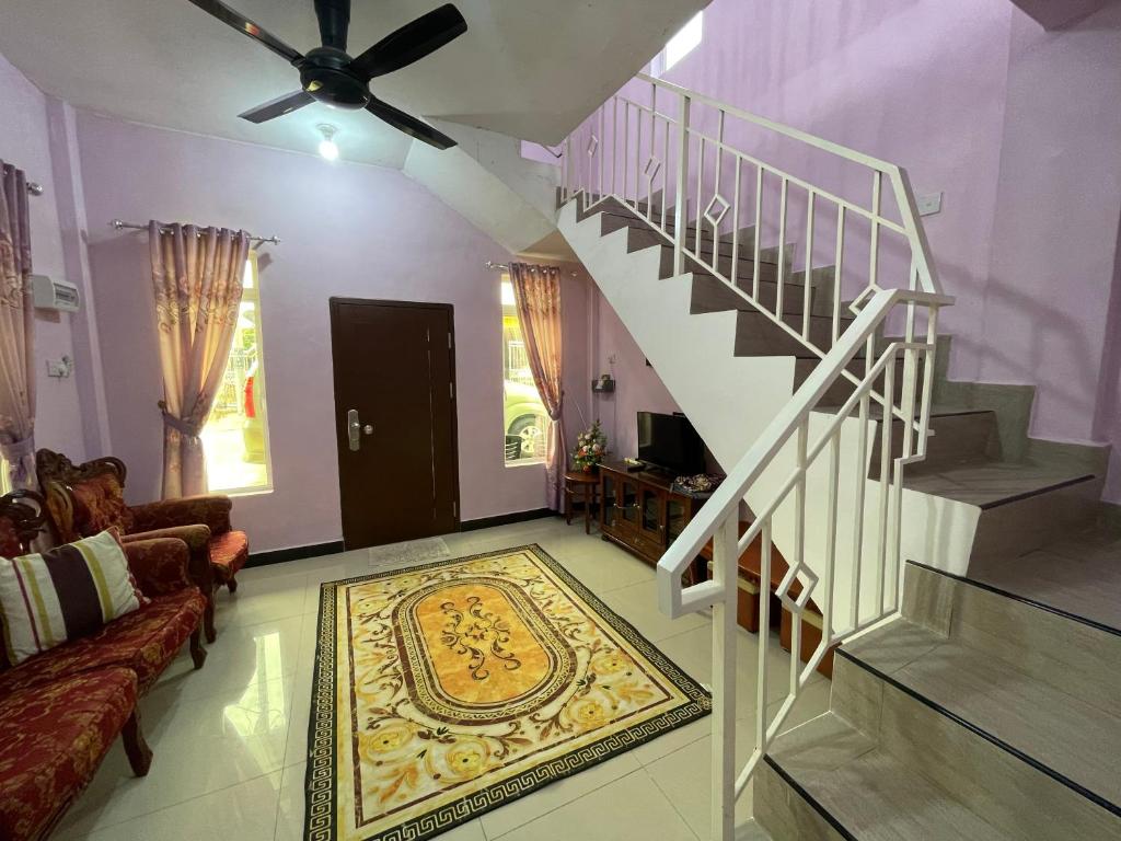 a living room with a staircase and a rug at Dan's Homestay Bangau in Temerloh