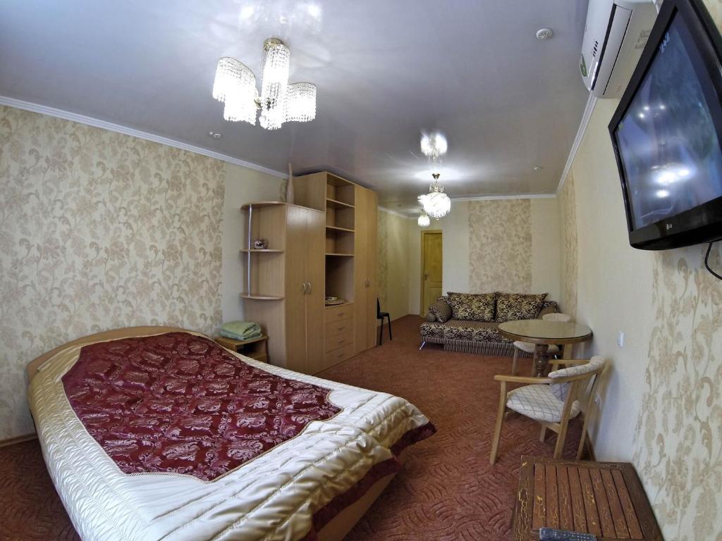 a bedroom with a bed and a flat screen tv at Hotel Katrin in Vinnytsya