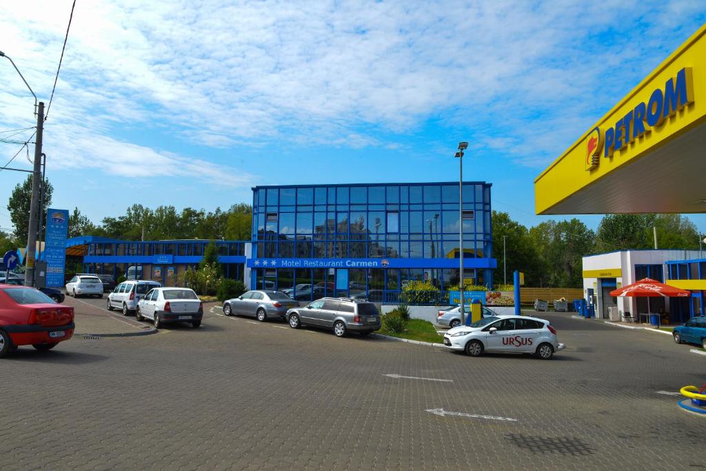 un estacionamiento con autos estacionados frente a un edificio en Motel Carmen, en Baia Mare