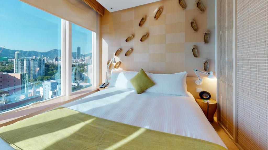 Un dormitorio con una cama y una ventana grande. en Hotel Madera Hong Kong, en Hong Kong