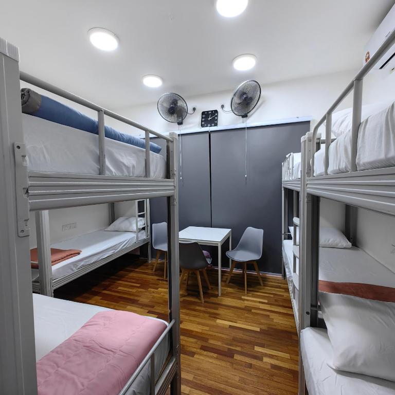 a room with three bunk beds and a desk at VnV DORM HOMESTAY in Shah Alam