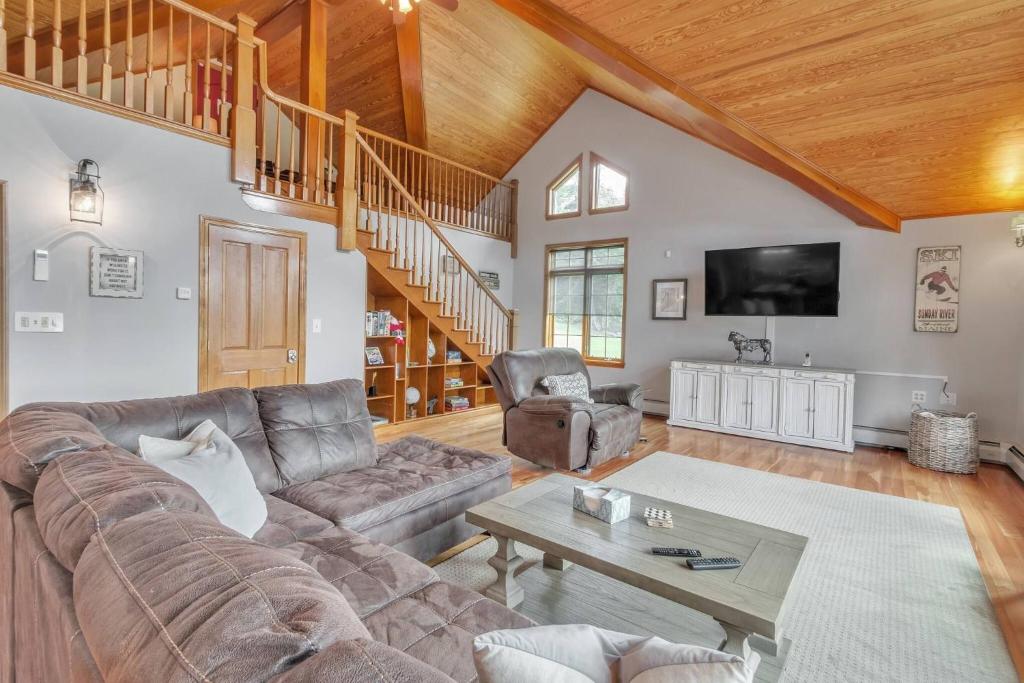una sala de estar con un sofá y una mesa en Mountain Retreat with River Views Near Sunday River and Year-Round Adventure, en South Rumford