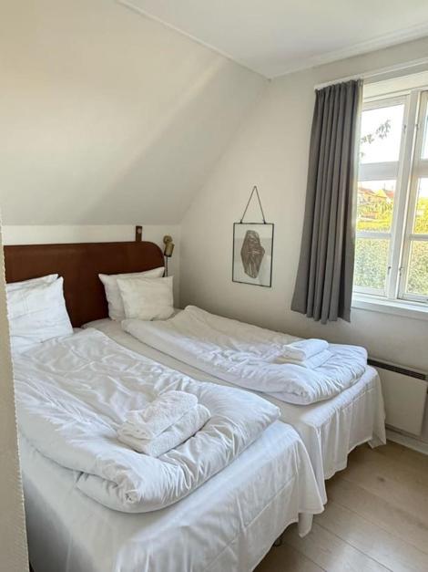 two twin beds in a room with a window at Villa Koch X Pension Koch in Gudhjem