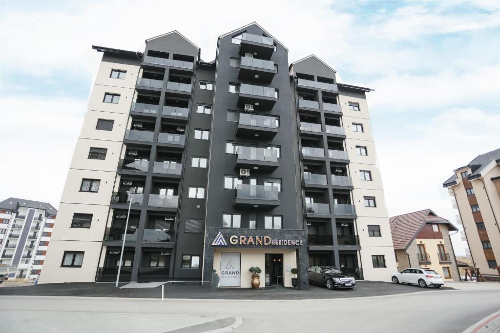 a tall building with a car parked in front of it at Grand Residence Zlatibor in Zlatibor