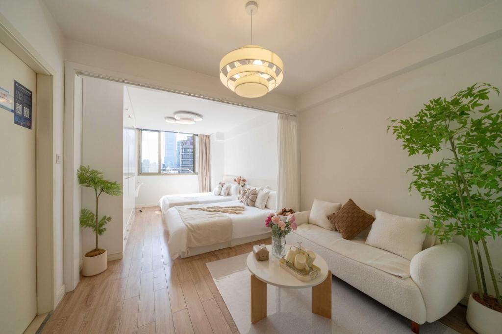 ein Wohnzimmer mit einem Bett und einer Couch in der Unterkunft HuanYu in Shanghai