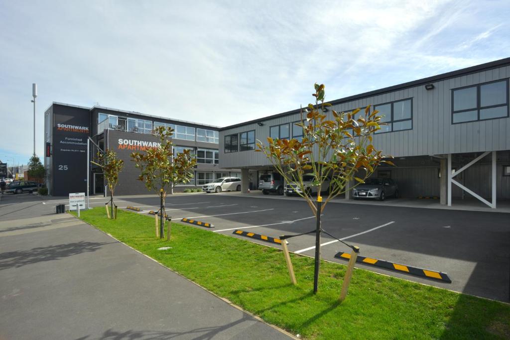 um parque de estacionamento com árvores em frente a um edifício em Southwark Hotel & Apartments em Christchurch