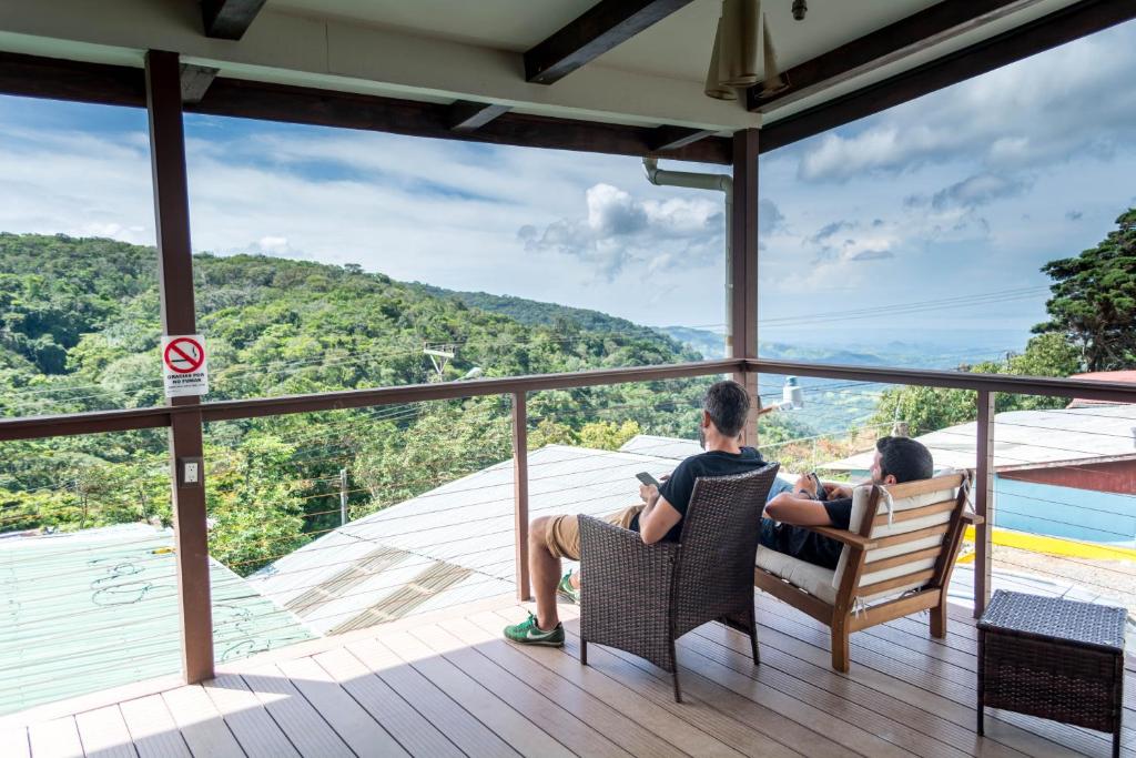 um grupo de pessoas sentadas em cadeiras num deque com vista em Camino Verde B&B Monteverde Costa Rica em Monteverde