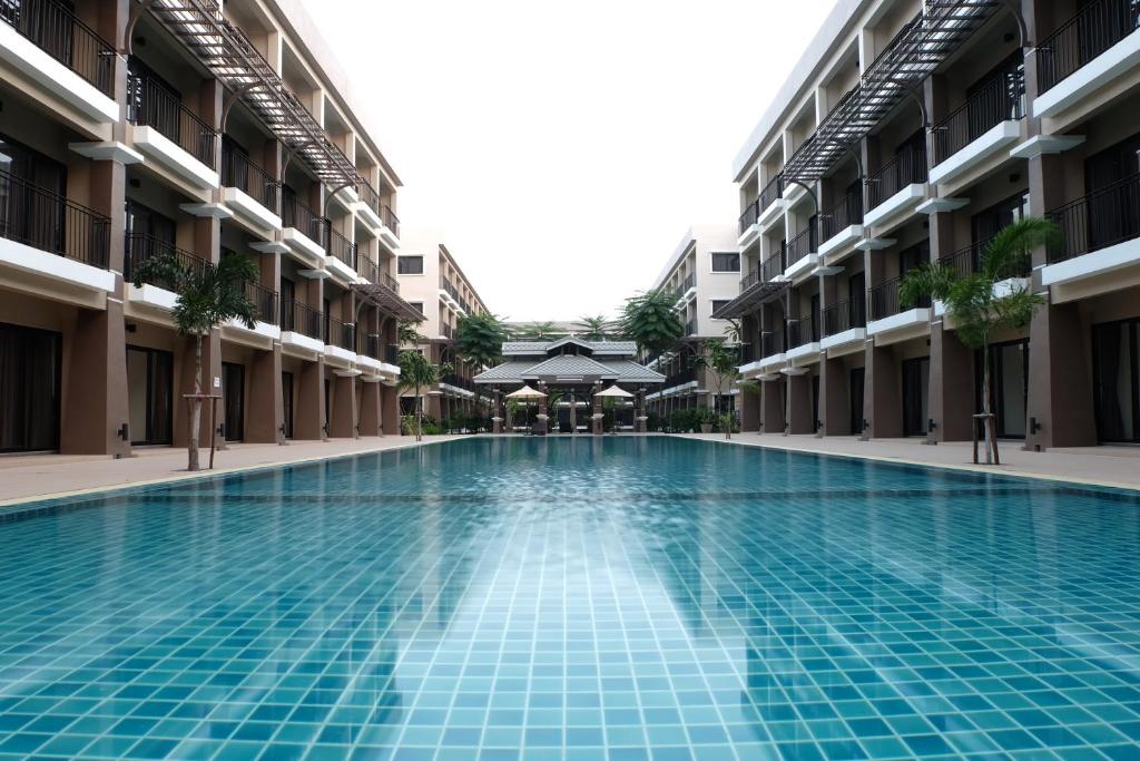 ein Schwimmbad in der Mitte eines Gebäudes in der Unterkunft Summer Tree Hotel in Bangna