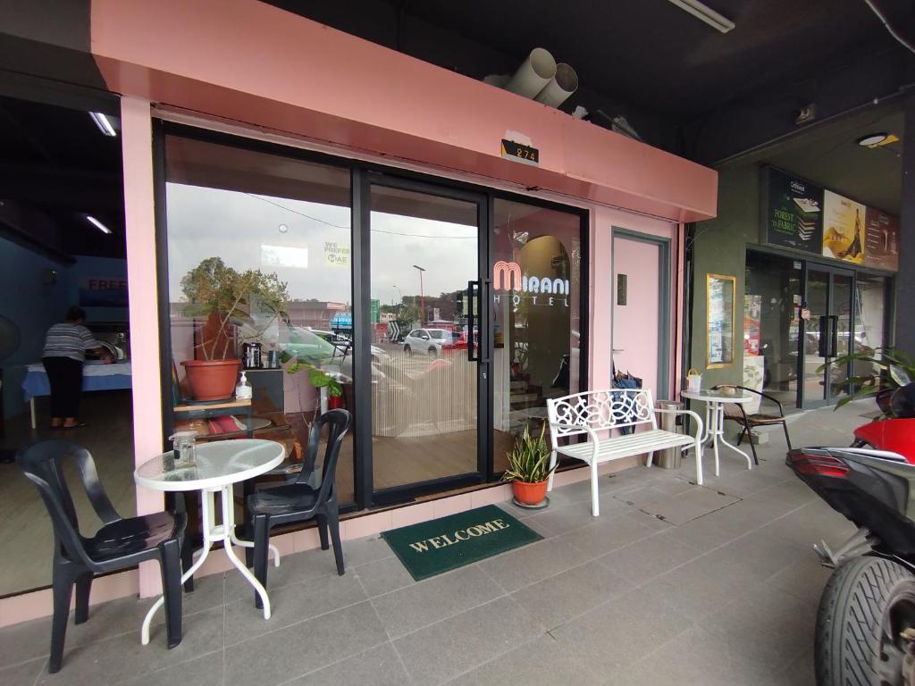 ein Restaurant mit Tischen und Stühlen außerhalb eines Ladens in der Unterkunft Mirani Hotel in Kuala Lumpur