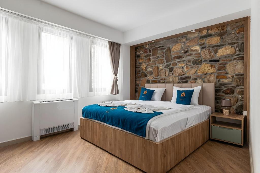 a bedroom with a large bed and a stone wall at Old Stone Hotel Skopje in Skopje