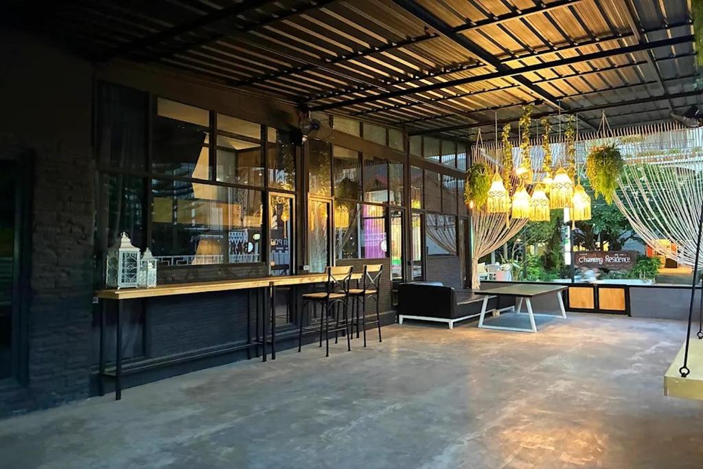 a room with a bar with chairs and a table at Lazy Lizard Hostel in Ban Nong Chaeng