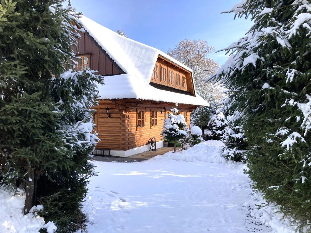 a log cabin with snow on the roof at Liptovská Drevenica in Liptovský Mikuláš
