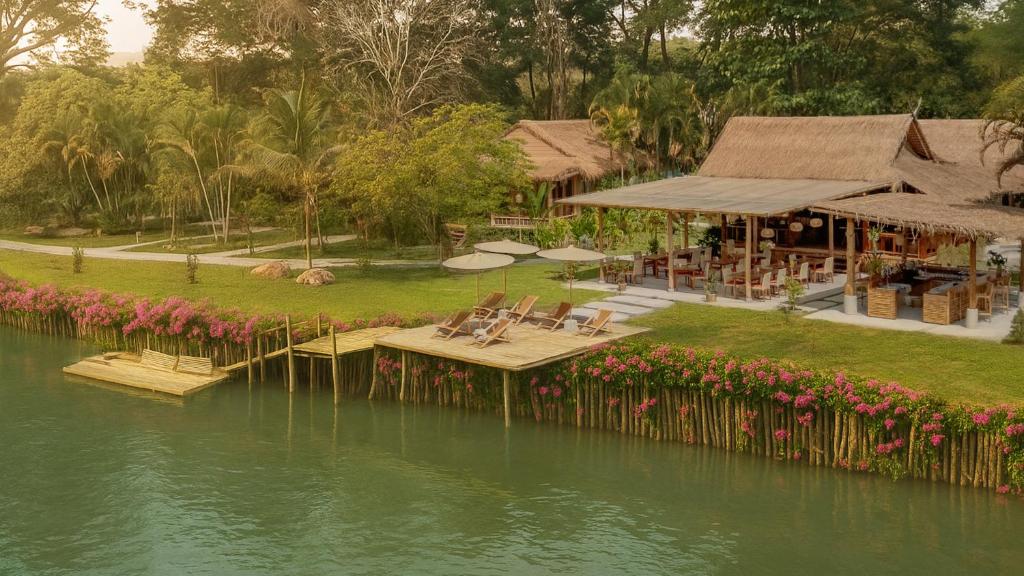 a house with a dock in the middle of the water at The Riverfront Reserve in Pai